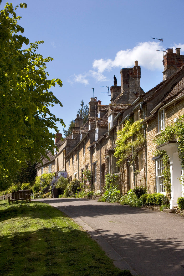 Row of houses with tiled roofs and greenery along a street